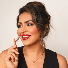  Woman holding a lip pencil against a plain background