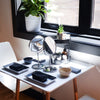 a table set for two with bowls, trays, napkins, spoons, mirrors, and a skincare carousel